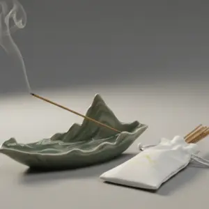 ceramic incense stick holder with lotus leaf design on white background